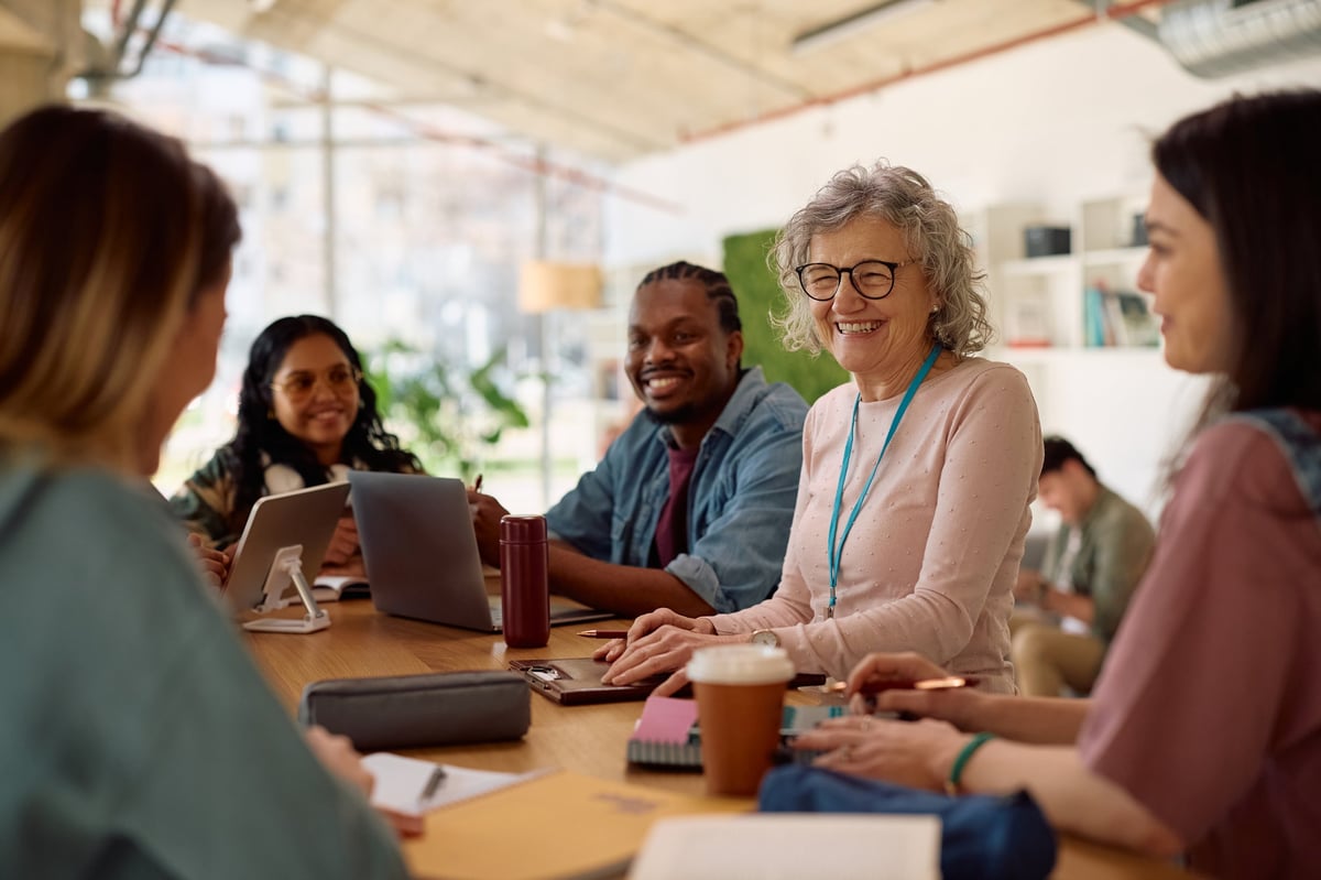 A woman scholar teaching and mentoring a diverse room of women