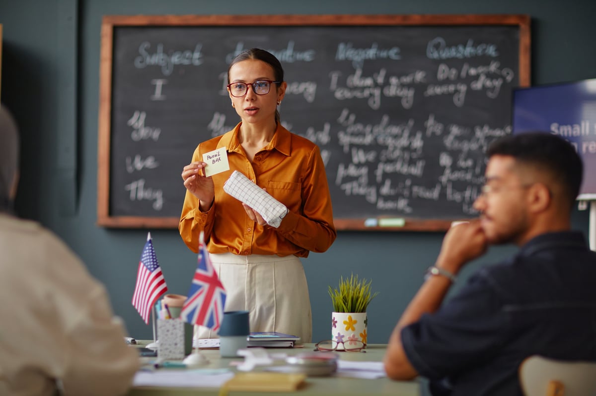A woman educator guiding a small group of adult learners, the structured work of restoration programming